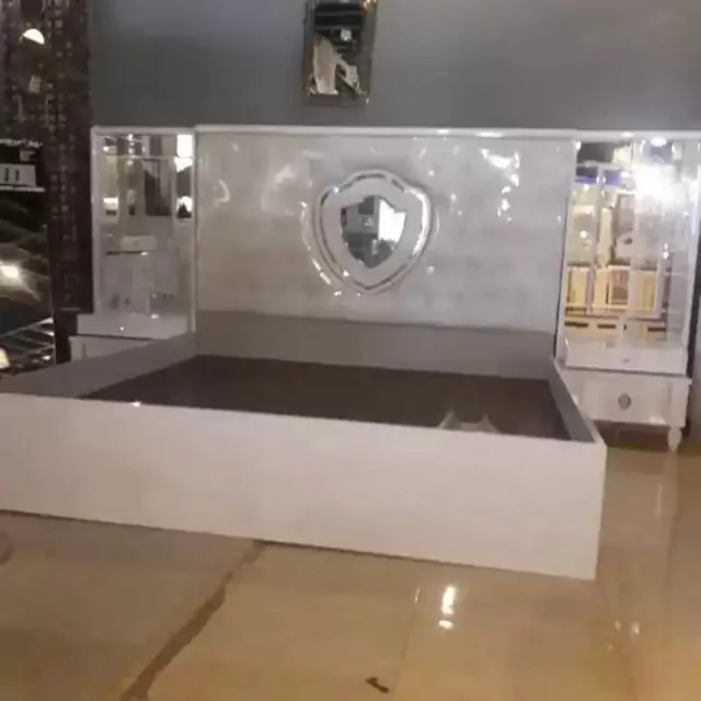 سرير مع لوح خلفي مزخرف ووحدات جانبية.